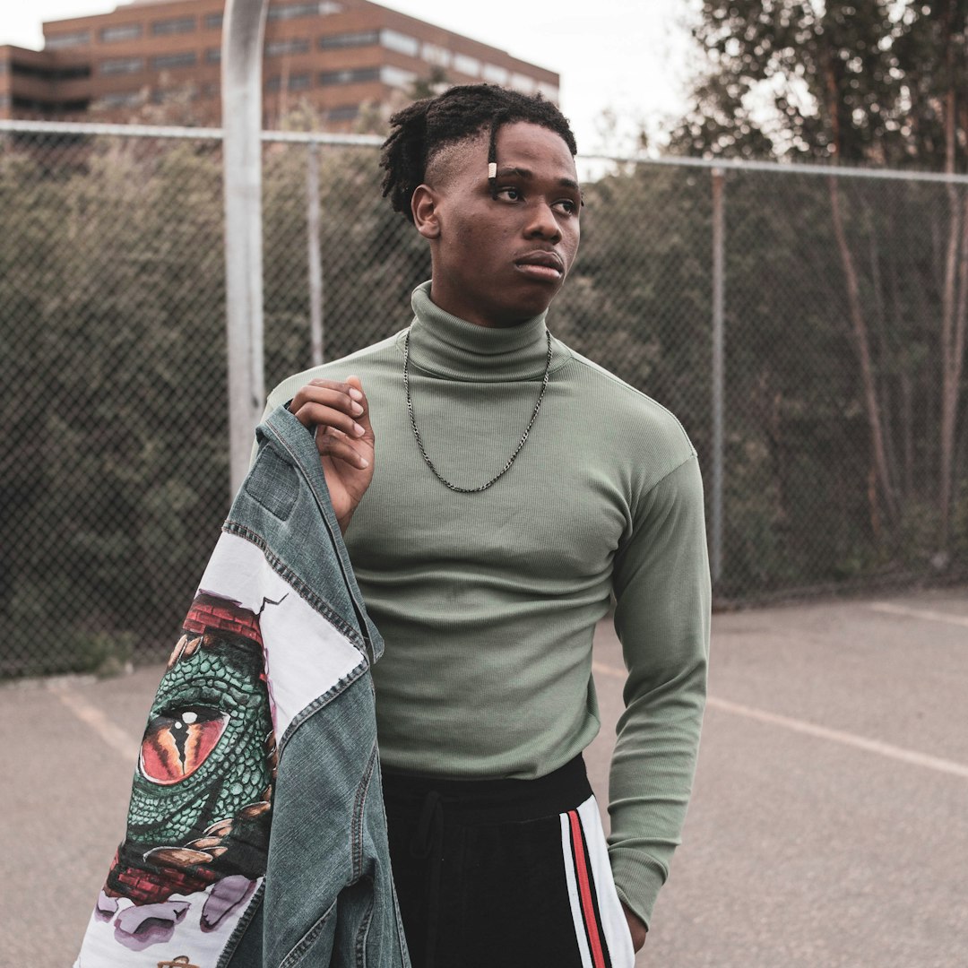 man in green long sleeve shirt holding white and red textile