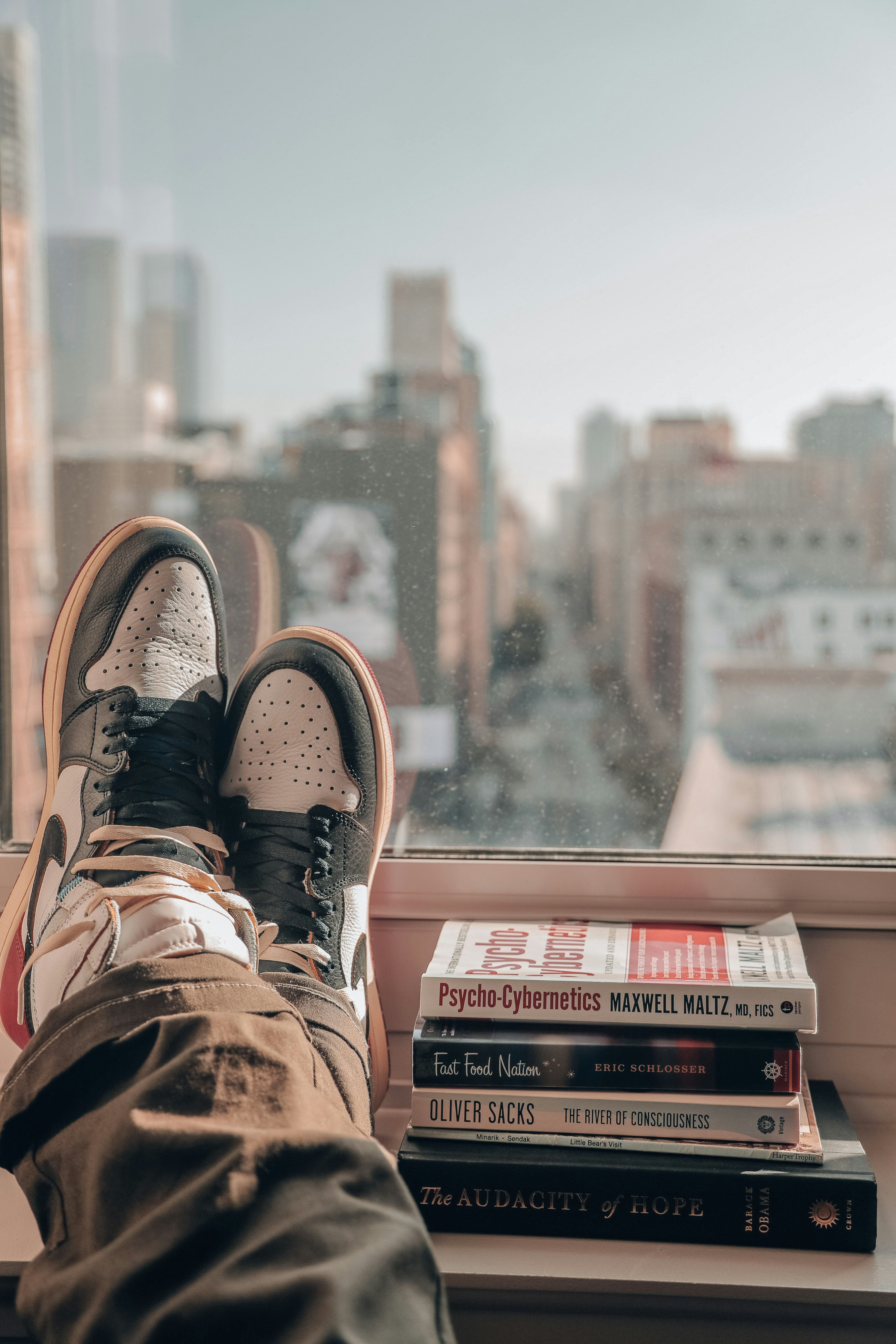 person in brown hiking shoes sitting on top of building during daytime