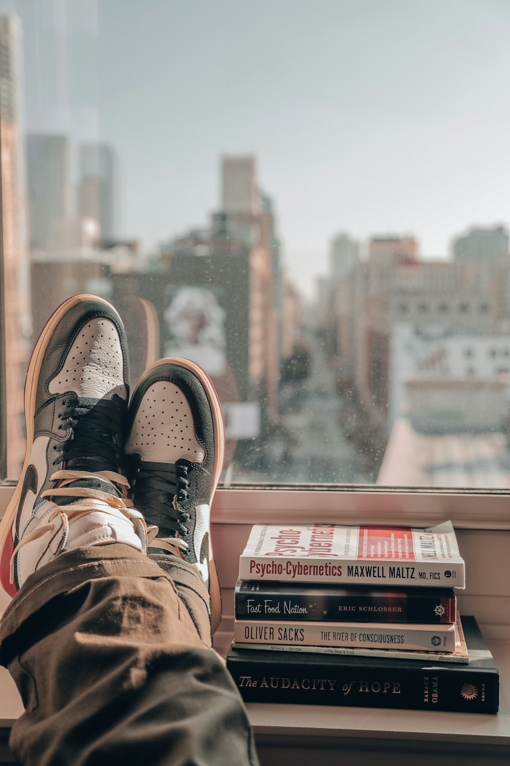 person in brown hiking shoes sitting on top of building during daytime