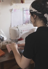 man in black shirt using sewing machine