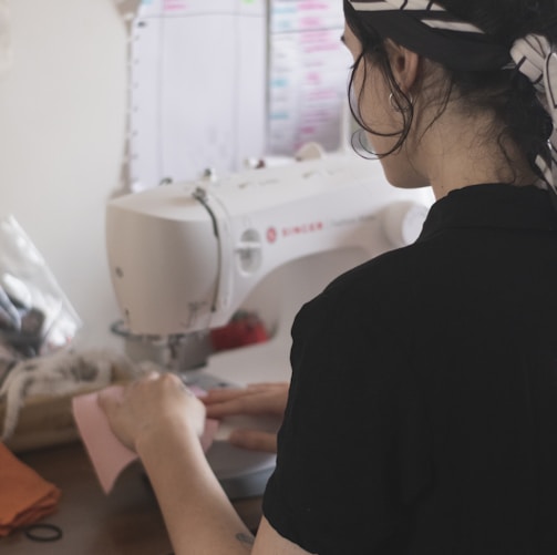 man in black shirt using sewing machine