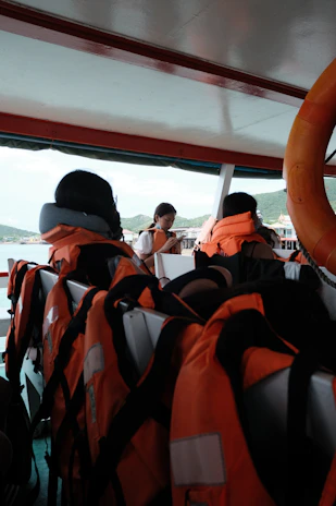Safety equipment neatly arranged on a boat deck, including life jackets and emergency signaling devices.