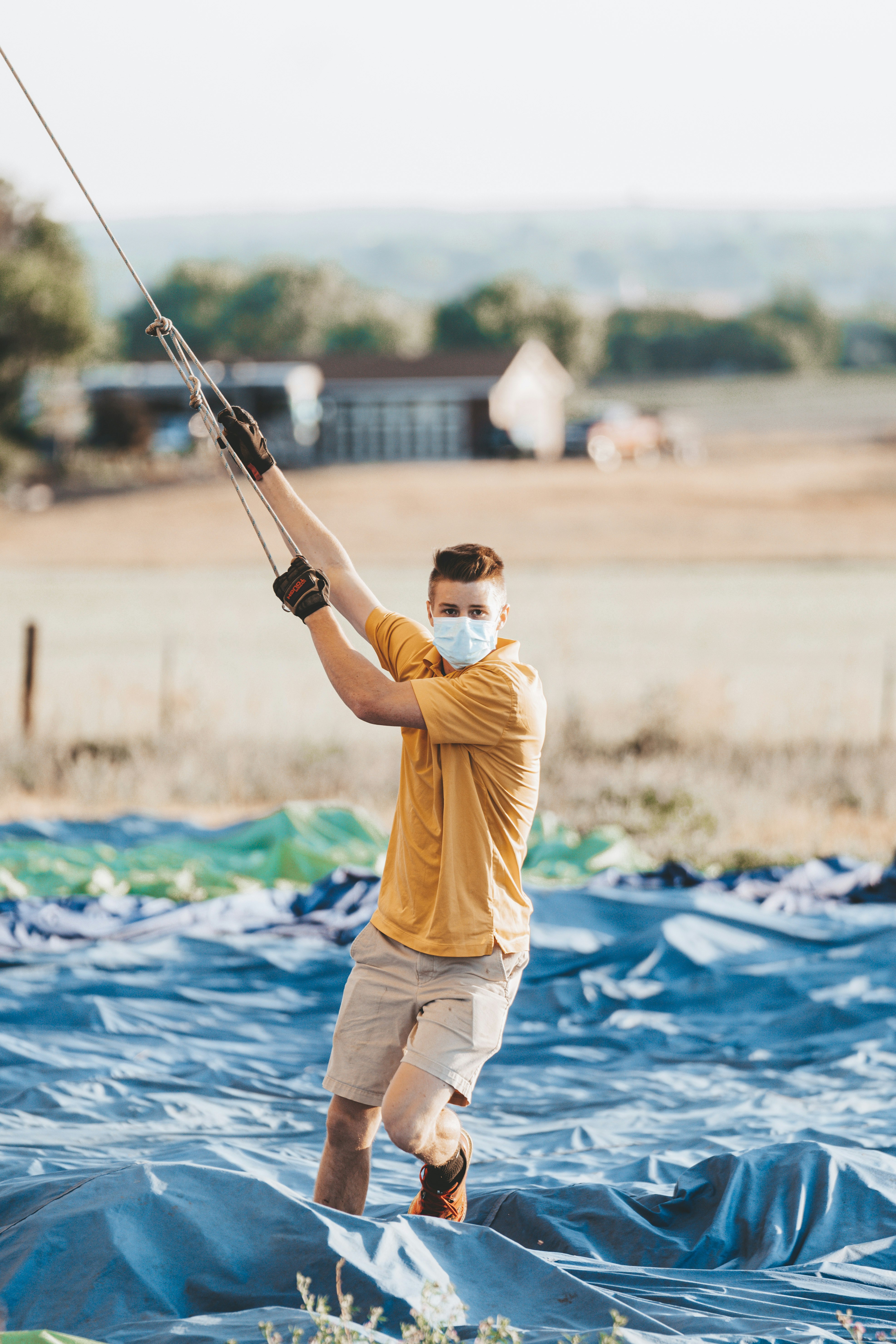 man in yellow shirt and white shorts holding black fishing rod