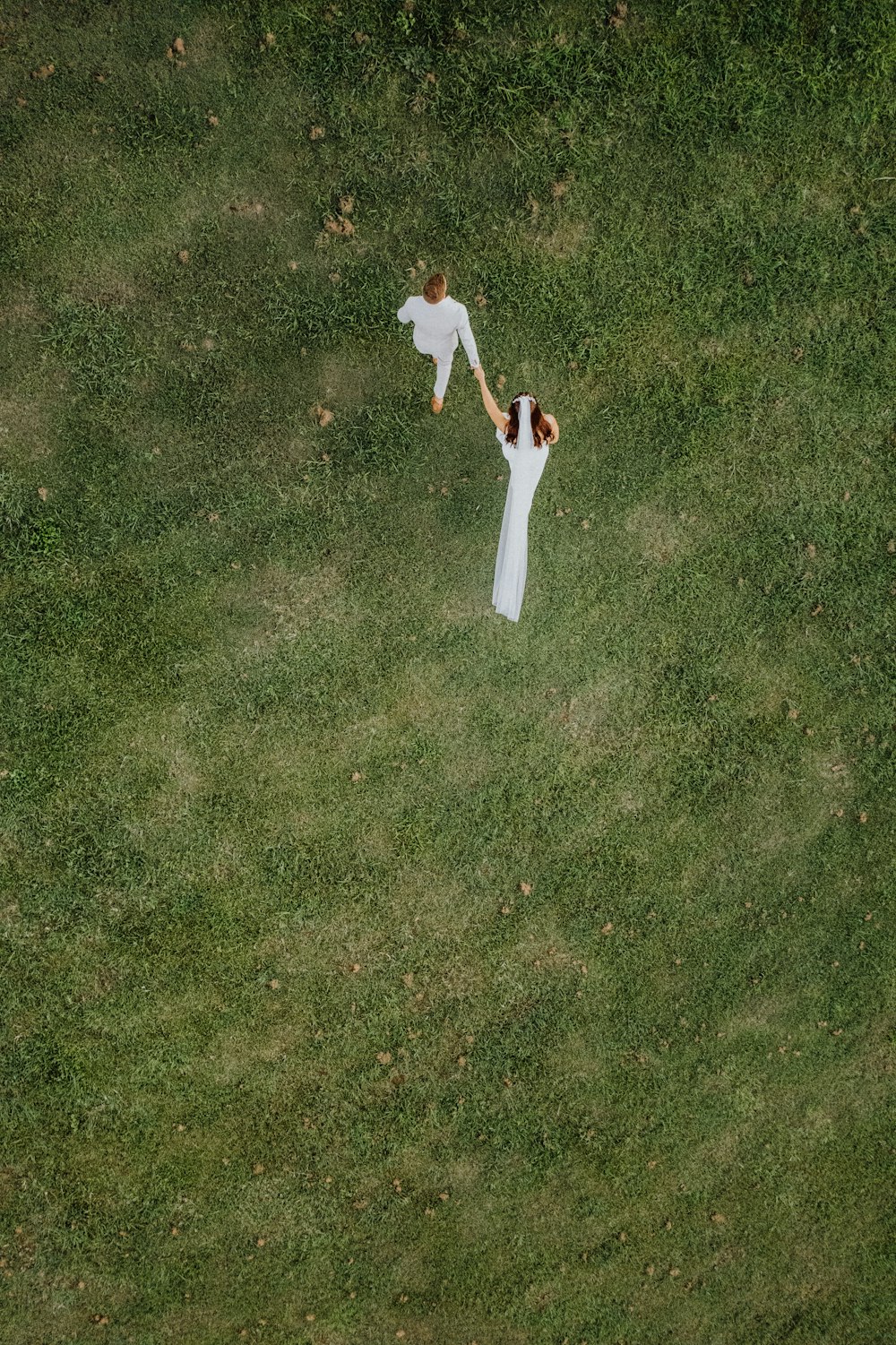 2 men in white long sleeve shirt and pants standing on green grass field during daytime