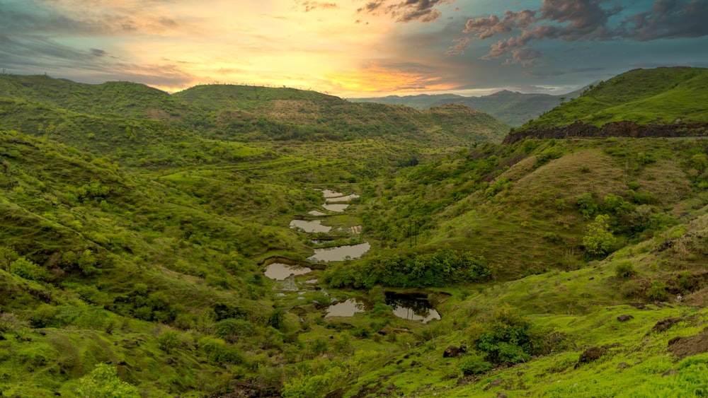 the sun is setting over a valley in the mountains