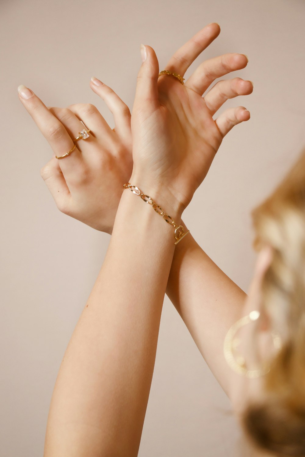 woman wearing gold ring and gold bracelet