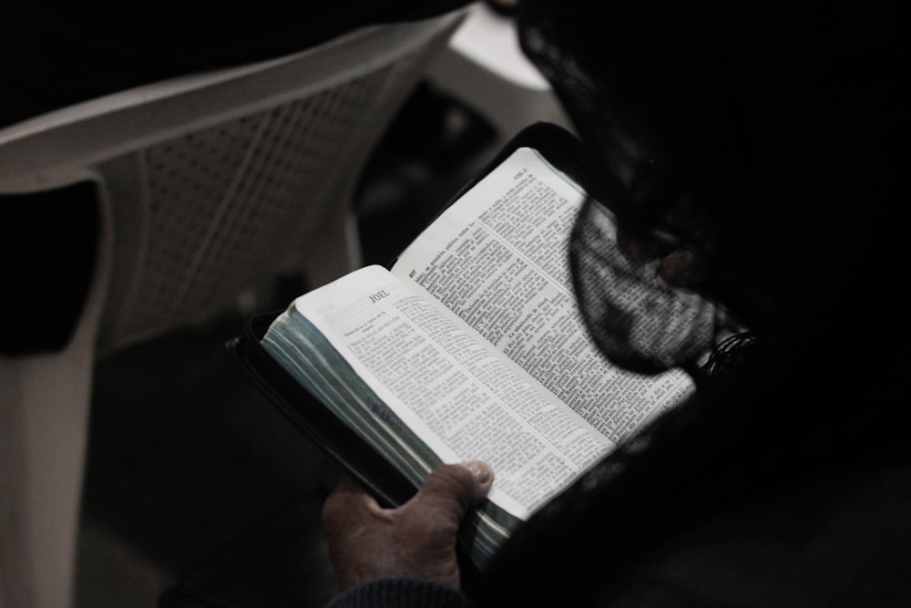 person reading book on table