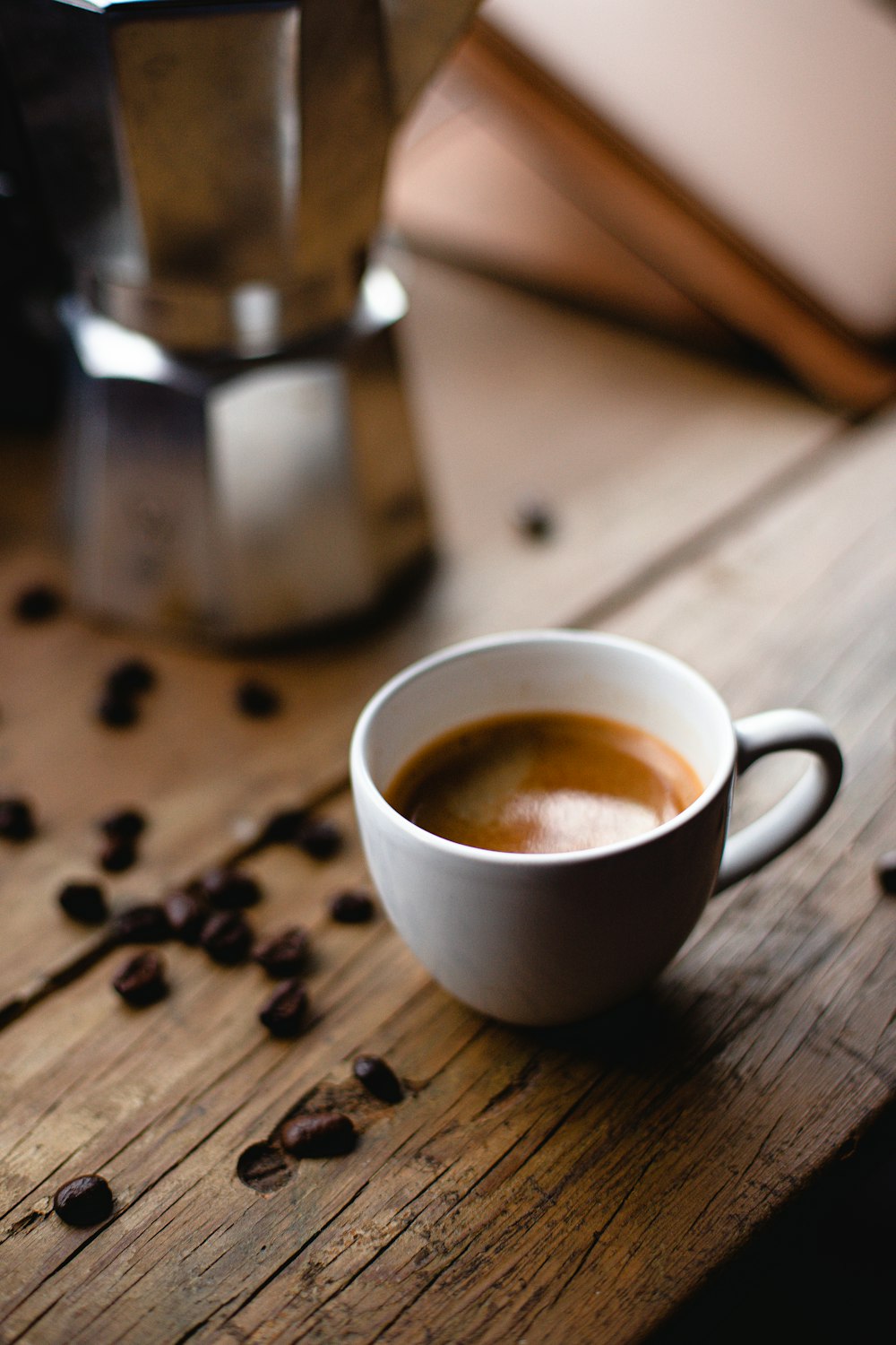 weiße Keramiktasse mit Kaffee auf braunem Holztisch