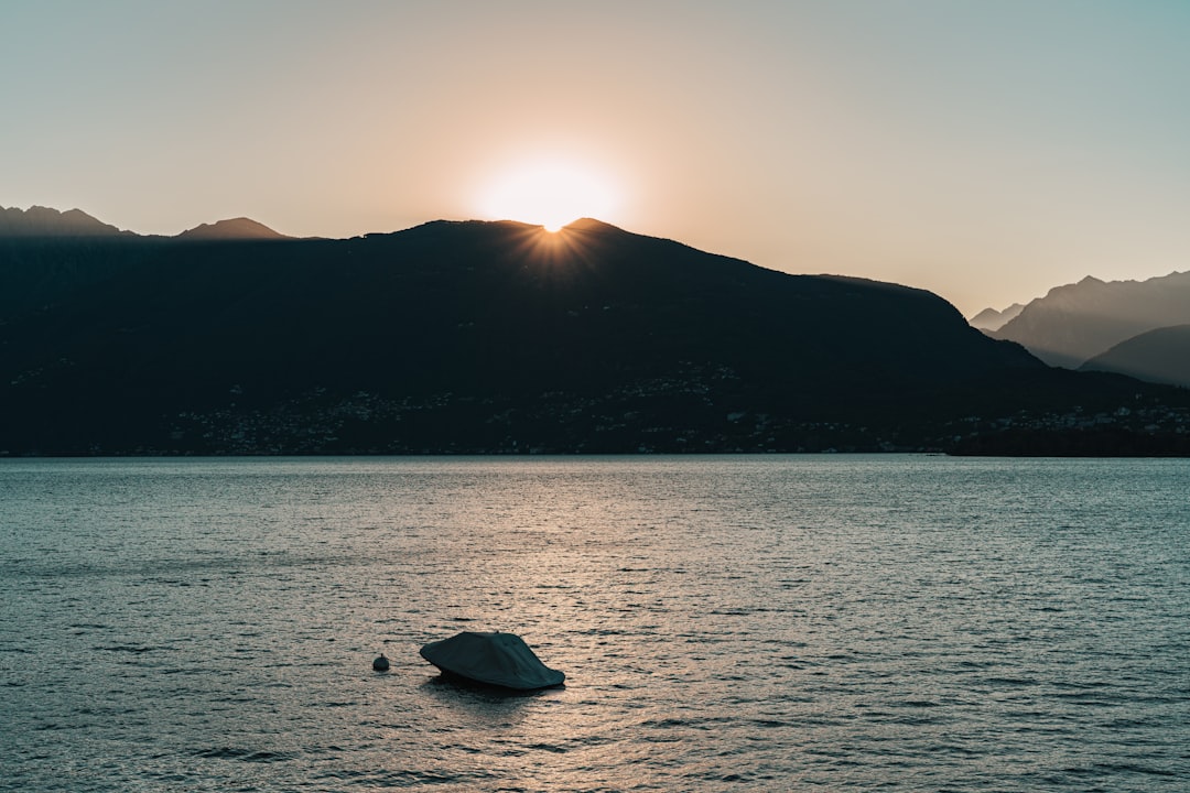 silhouette of mountain near body of water during sunset