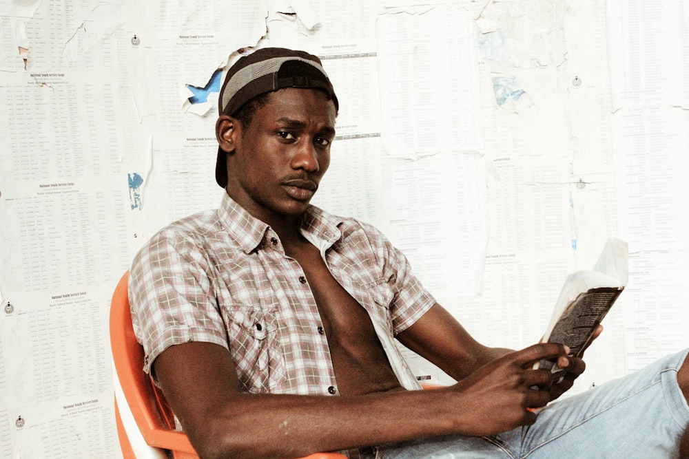 man in white and red plaid button up shirt sitting on red plastic chair