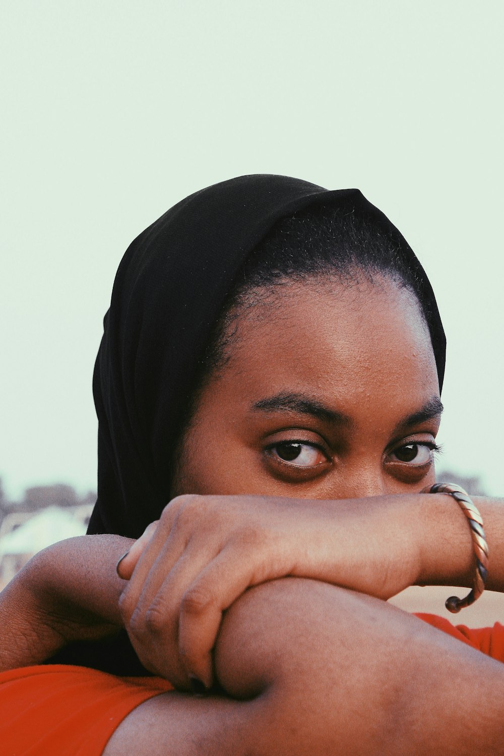 woman in black hijab covering her face with her hand