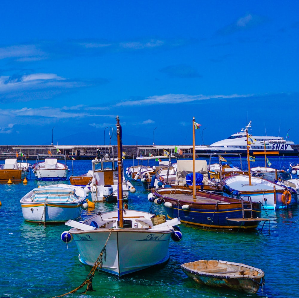 white and blue boats on sea under blue sky during daytime