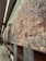 An extensive wall mural composed of various intricately designed tiles, each featuring unique patterns and designs. The mural exhibits a mixture of abstract and representational artwork with a blend of textures and colors. It stretches along a modern, well-lit corridor with smooth, reflective floors and overhead lighting.