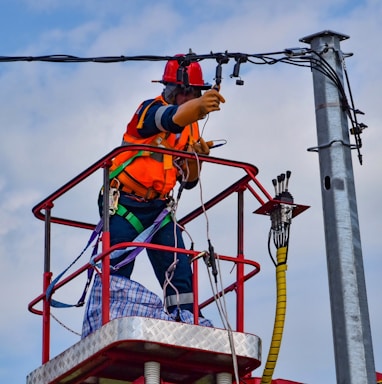 2 men in orange safety helmet riding on red and yellow cable car during daytime