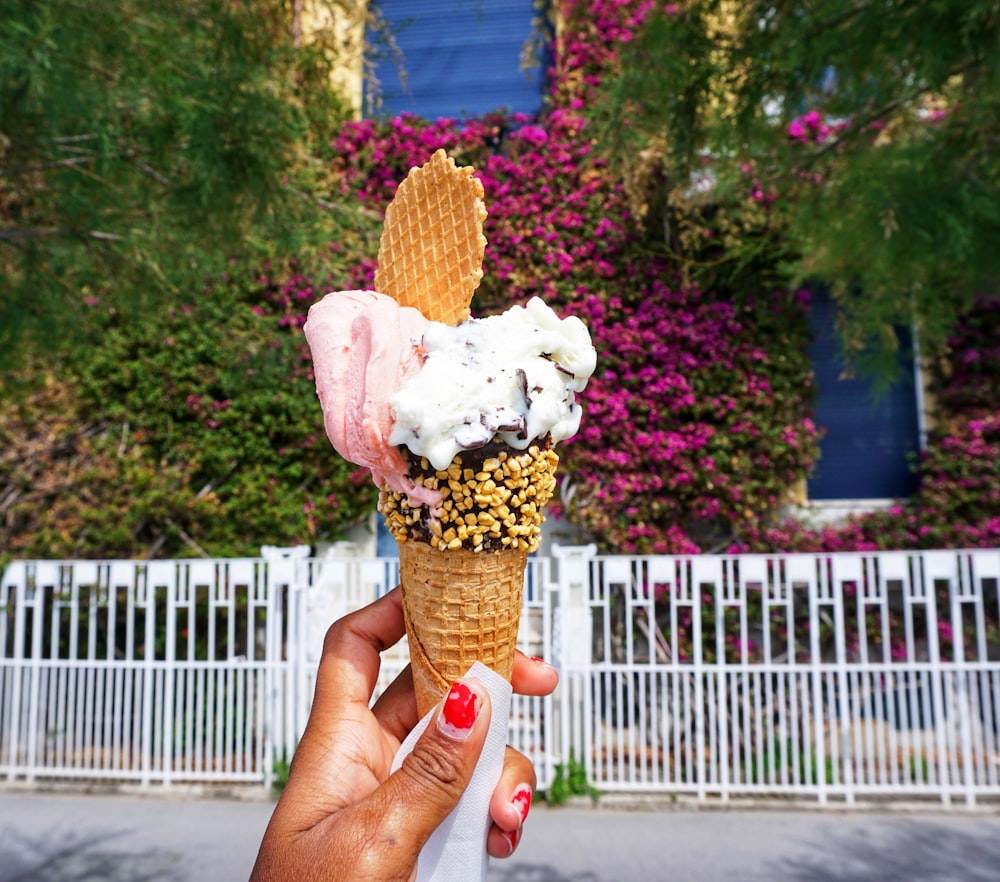 person holding ice cream cone with cone