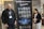 Two individuals stand on either side of a large banner for the BioPharmaceuticals Academy Masterclass. They both wear name tags and appear to be smiling. The banner lists various topics related to pharmaceuticals, including biologics and cell banks.