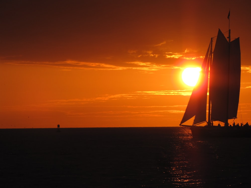 silhouette of sailboat on sea during sunset