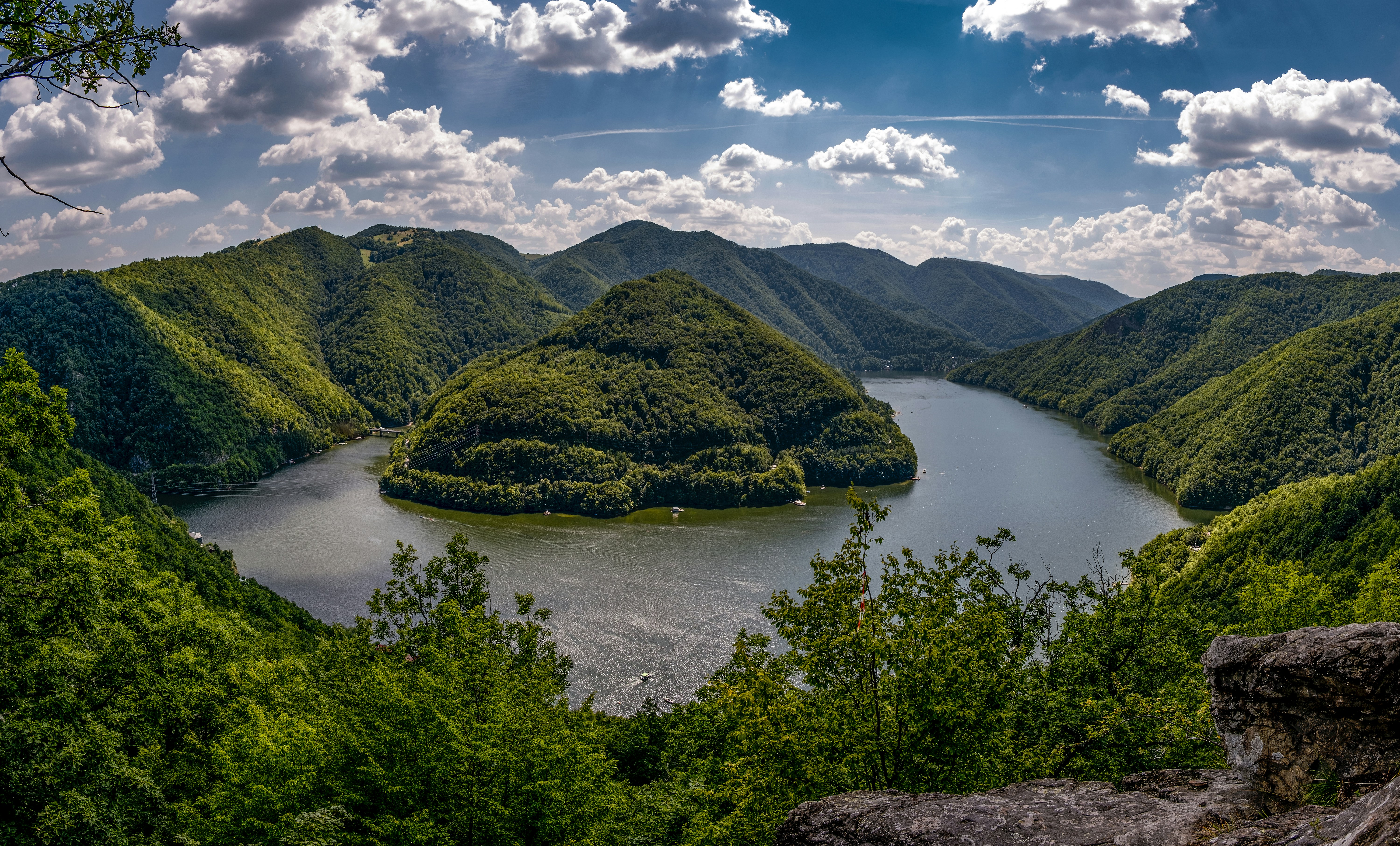 green mountain beside lake under blue sky during daytime