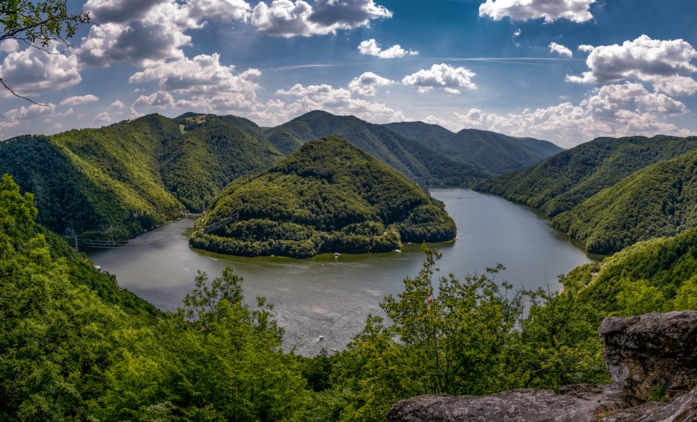 green mountain beside lake under blue sky during daytime