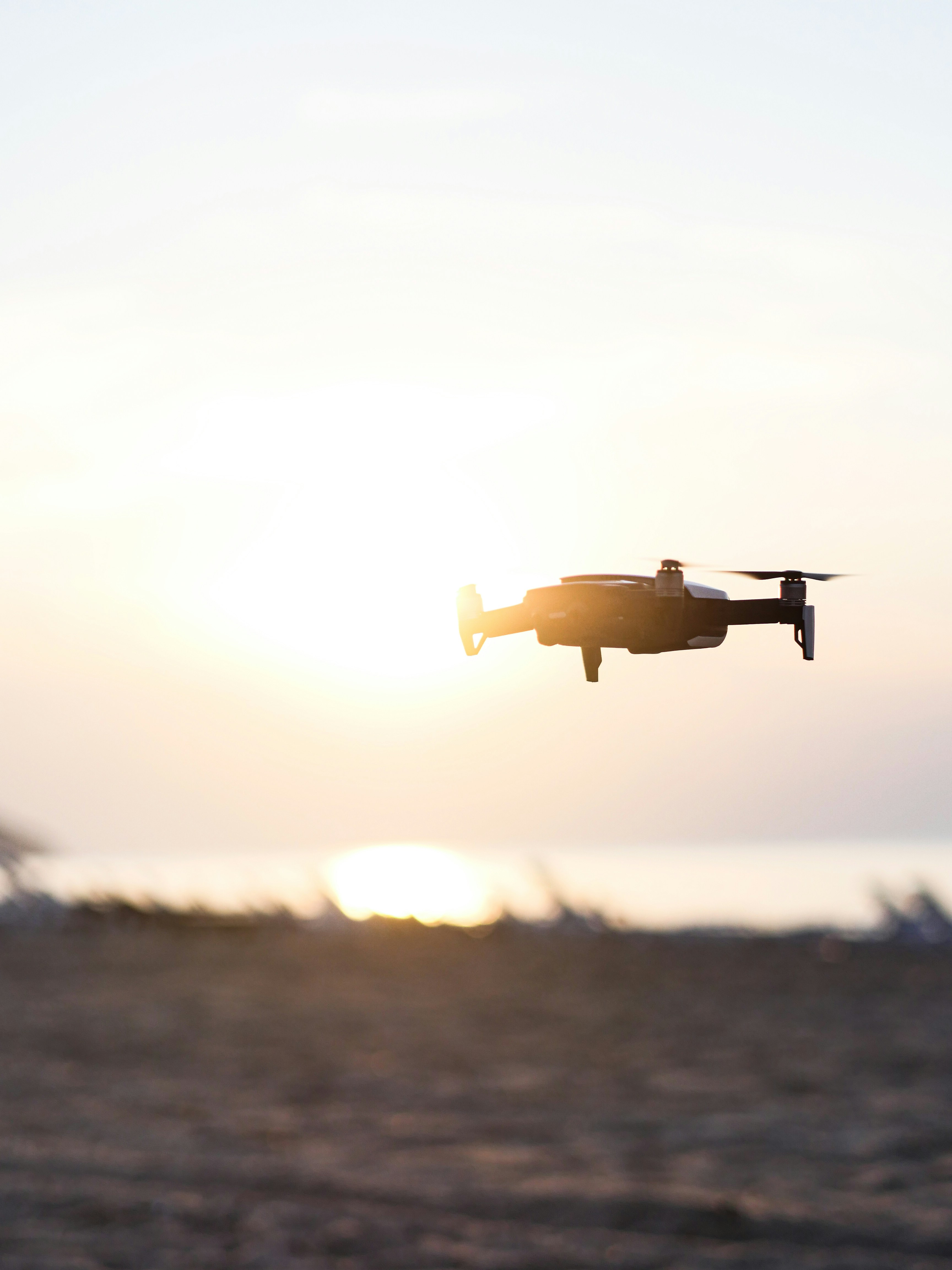 Weiße Drohne, die tagsüber über das Meer fliegt