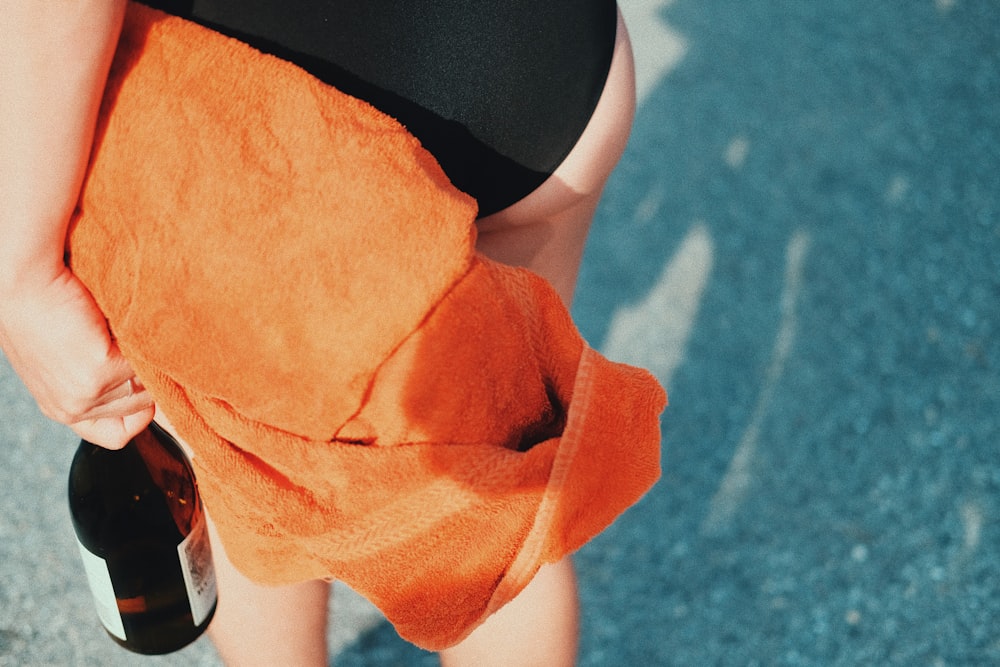 person in black shorts holding orange textile