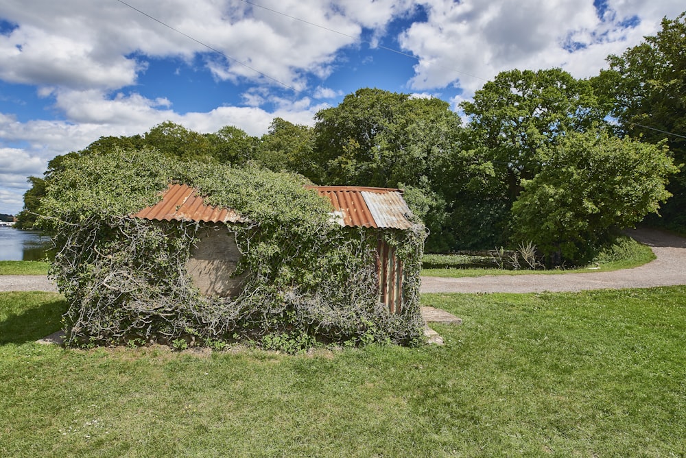 Maison en bois brun près des arbres verts sous le ciel bleu pendant la journée