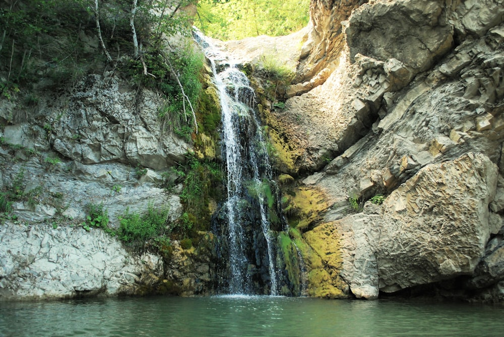 water falls between gray rock formation