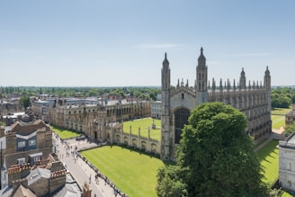 Aerial view of a historic university campus with Gothic-style buildings and lush green lawns
