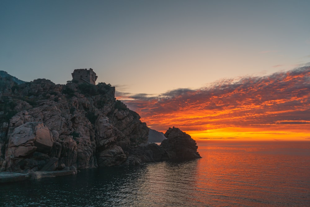 rock formation on sea during sunset