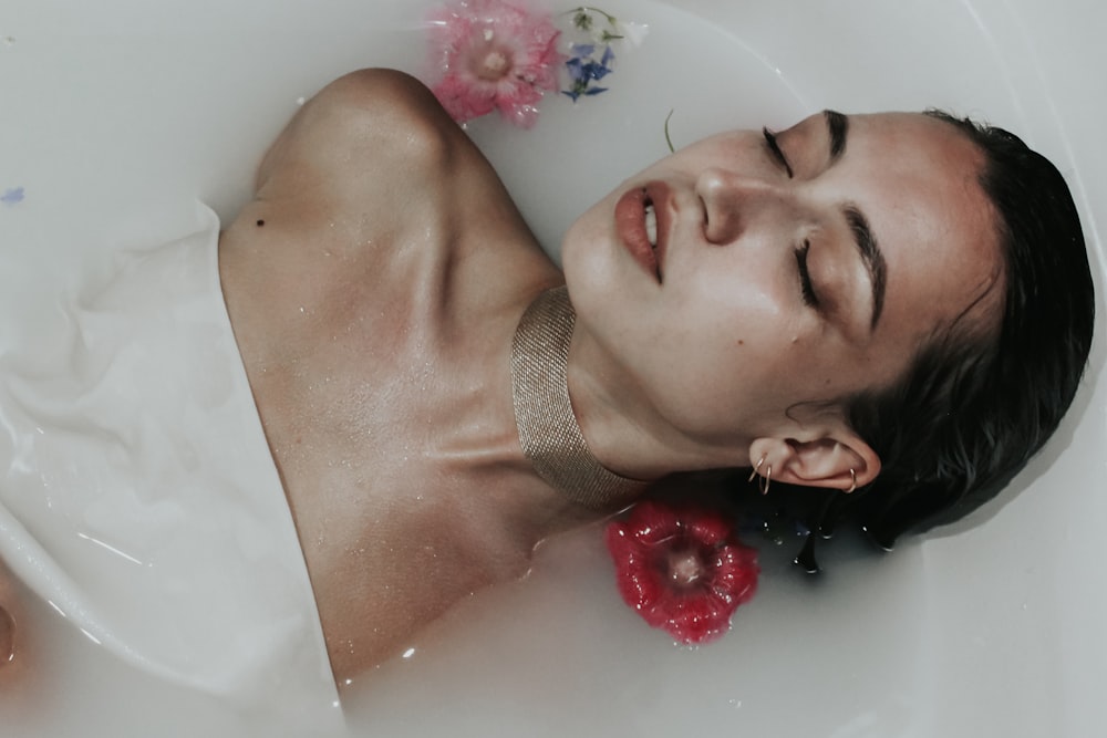 woman in bathtub with pink and white beads