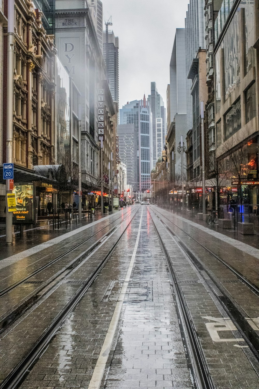 cars on road between high rise buildings during daytime