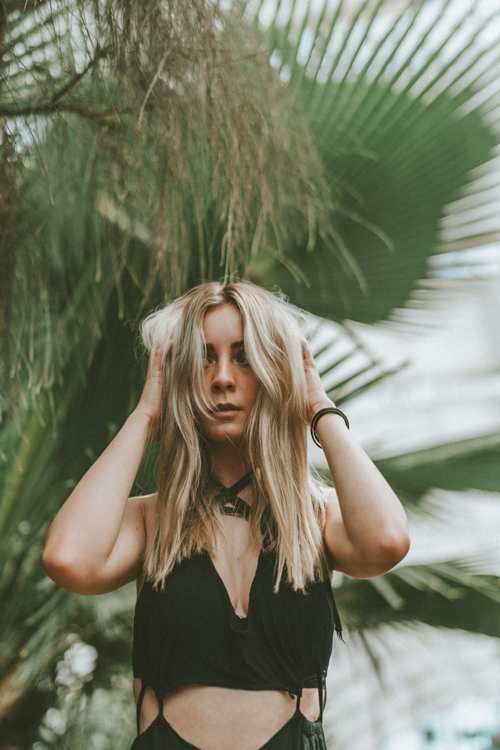 woman in black tank top standing near green grass during daytime