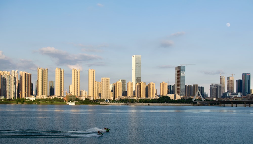 white boat on water near city buildings during daytime