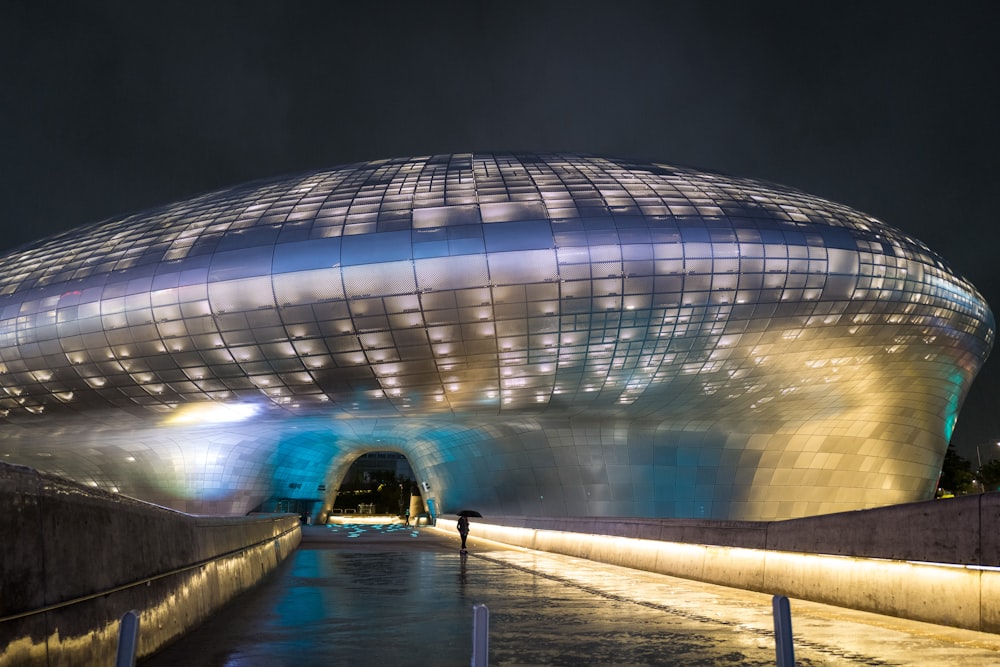 people walking near glass building during nighttime