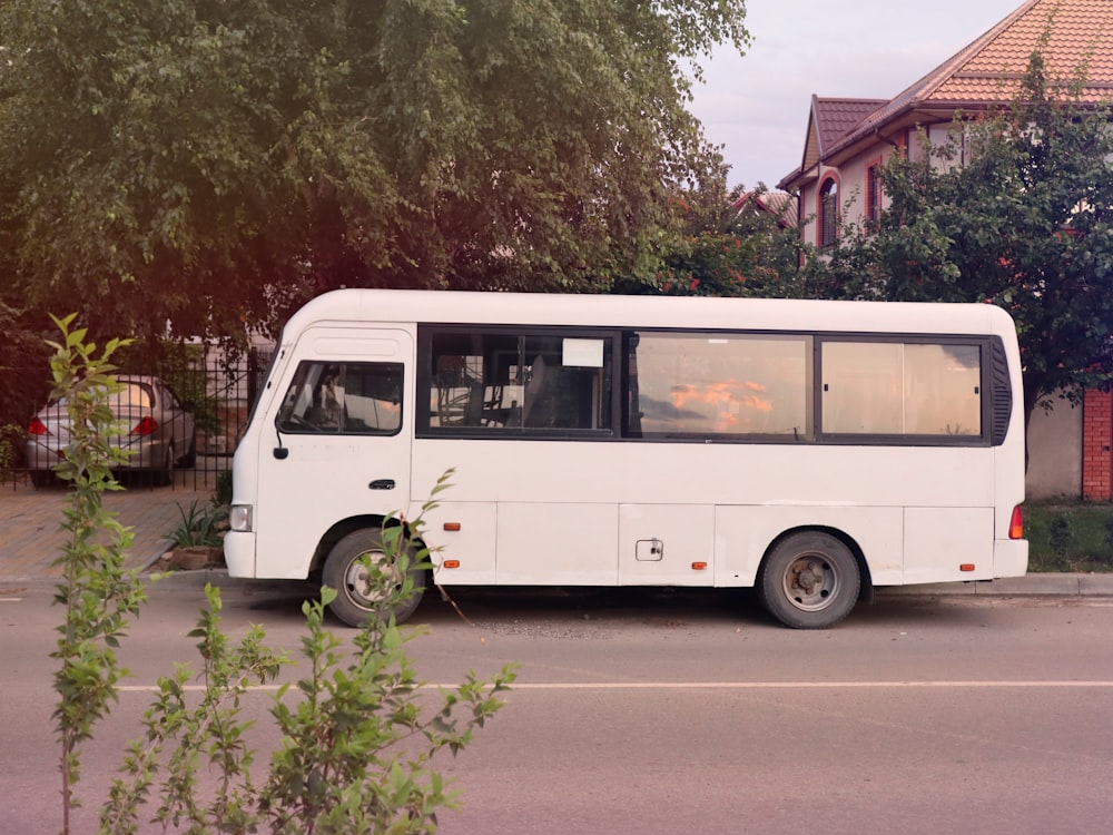 white and red volkswagen t-2 van parked near green trees during daytime