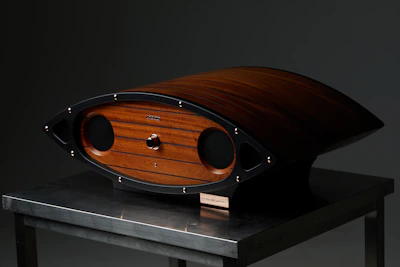 A sleek wireless speaker resting on a wooden table with soft ambient lighting.