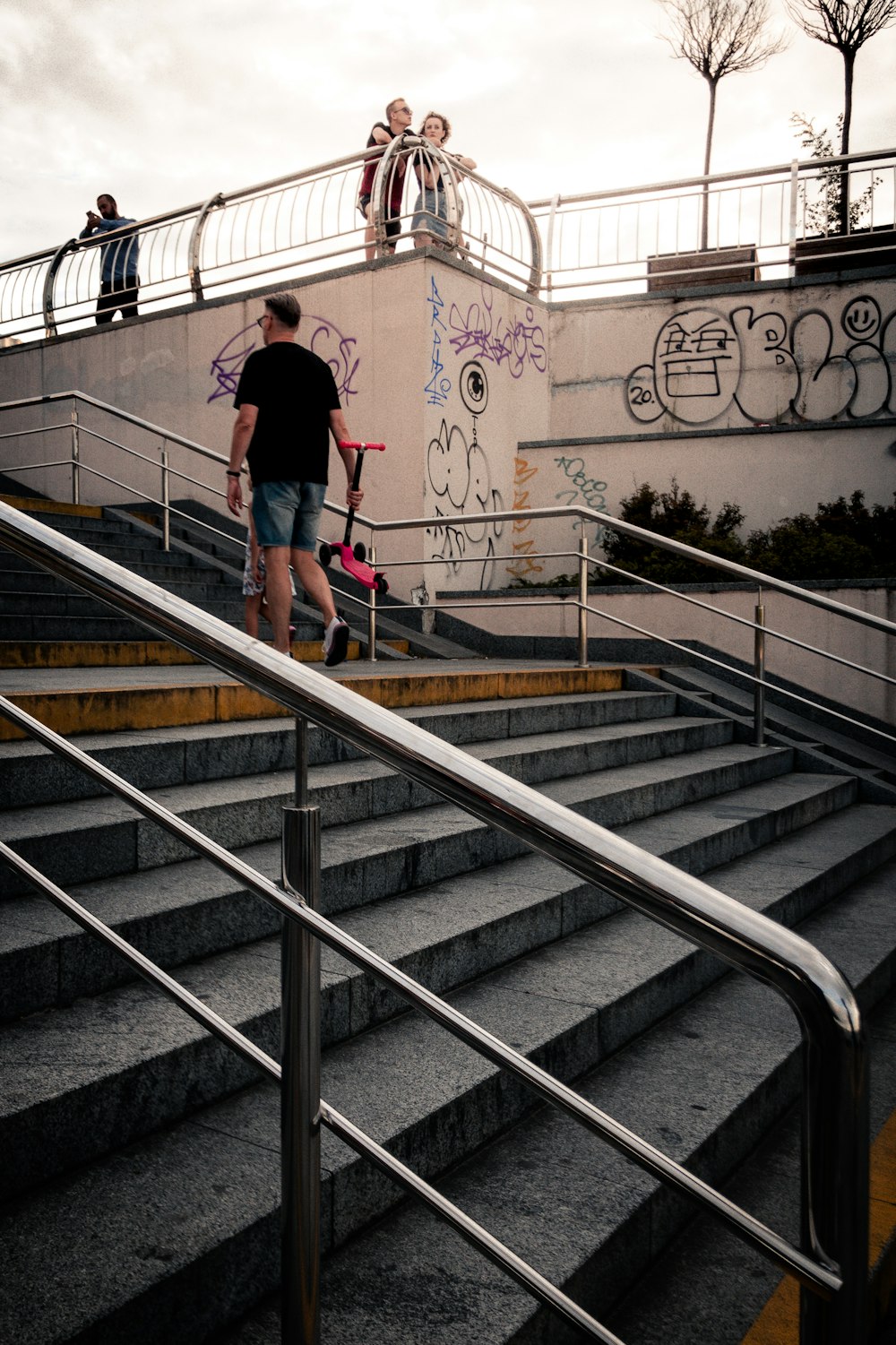 ピンクのシャツと青いデニムジーンズを着た女性が灰色のコンクリート階段を歩く