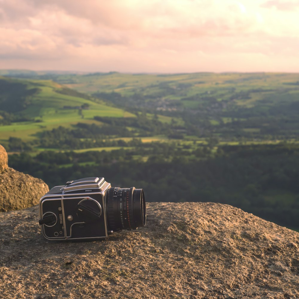 Fotocamera DSLR nera su roccia marrone