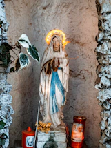 A peaceful altar with candles and a statue of the Virgin Mary glowing softly