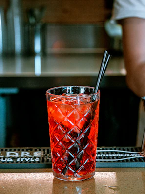 A heart horb drink in a stylish glass, with deep red hues contrasting the dark theme of the café