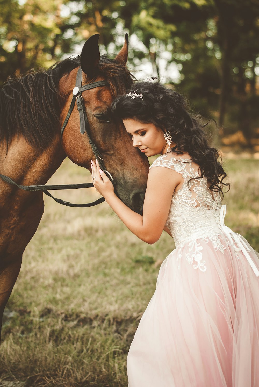 woman in white dress holding brown horse