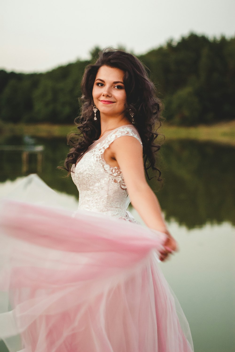 woman in white sleeveless dress standing near lake during daytime