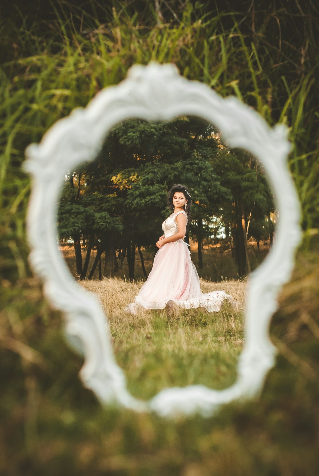 woman in white wedding dress standing on green grass field