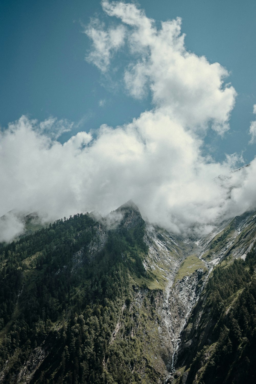 green mountain under white clouds and blue sky during daytime