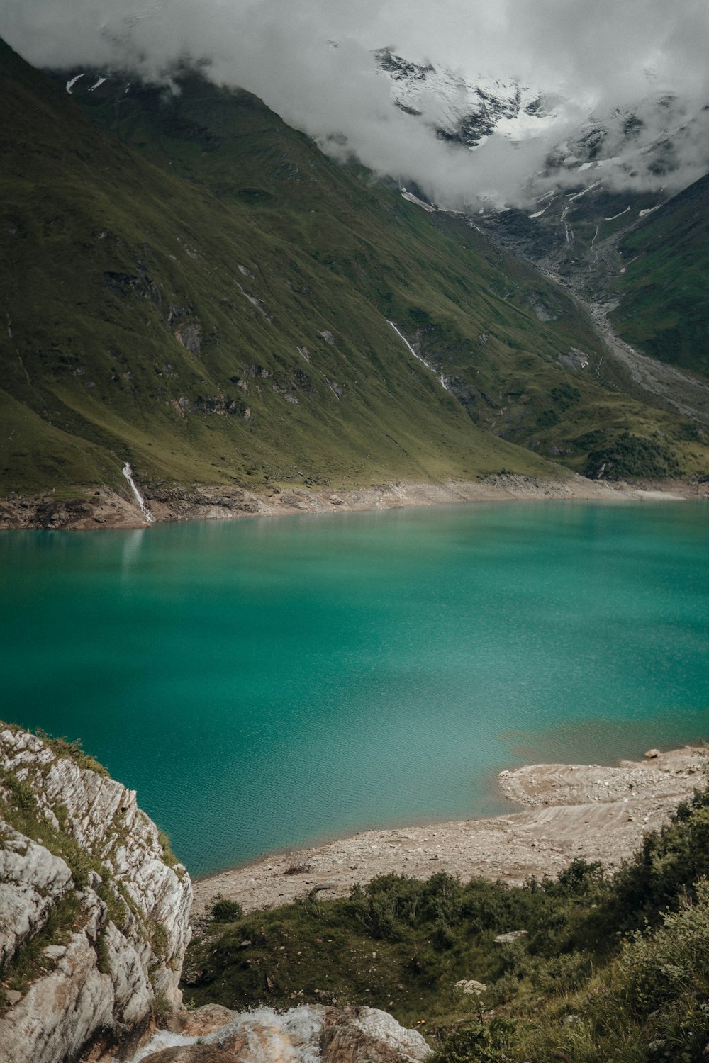 green lake between mountains during daytime