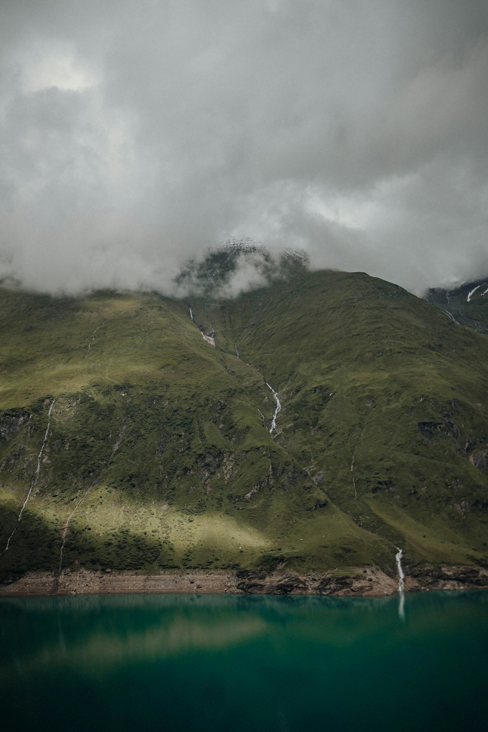 green mountain under white clouds during daytime