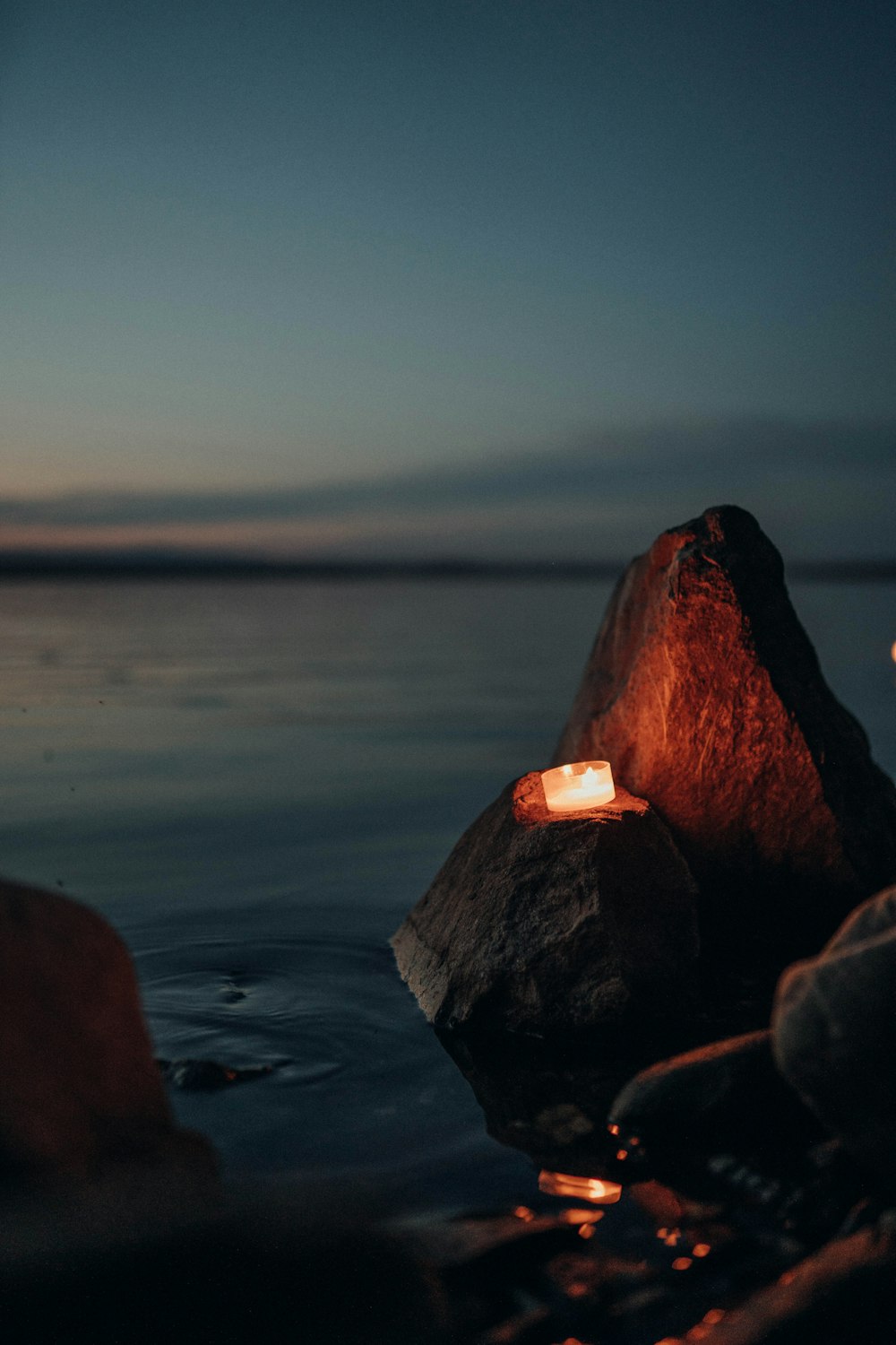 brown rock formation near body of water during sunset