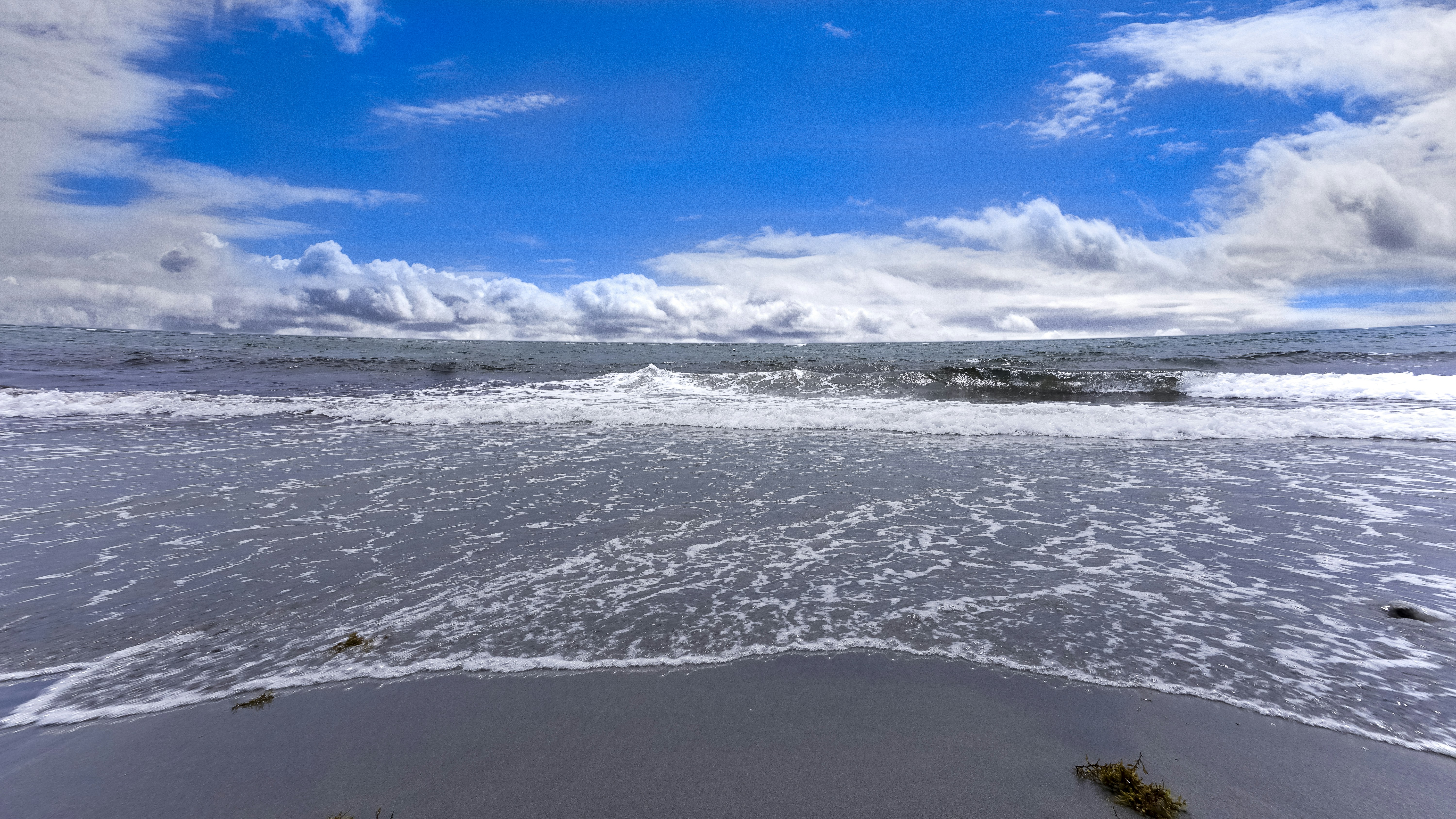 Ocean waves crashing on shore under blue sky and white clouds during ...