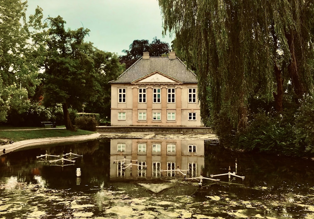 brown concrete building near green trees and river during daytime