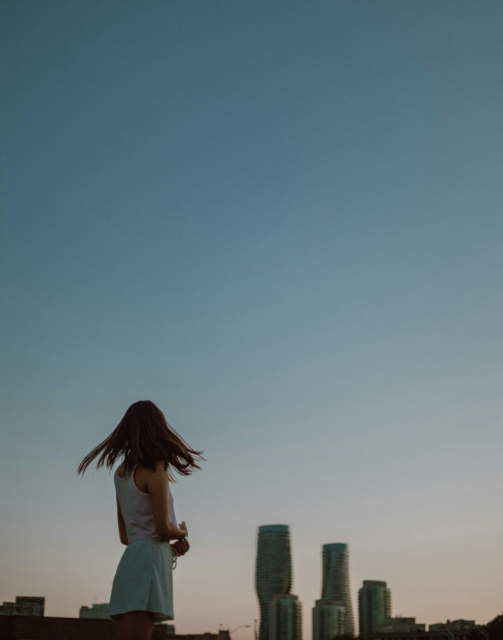 woman in white shirt standing on top of building during daytime